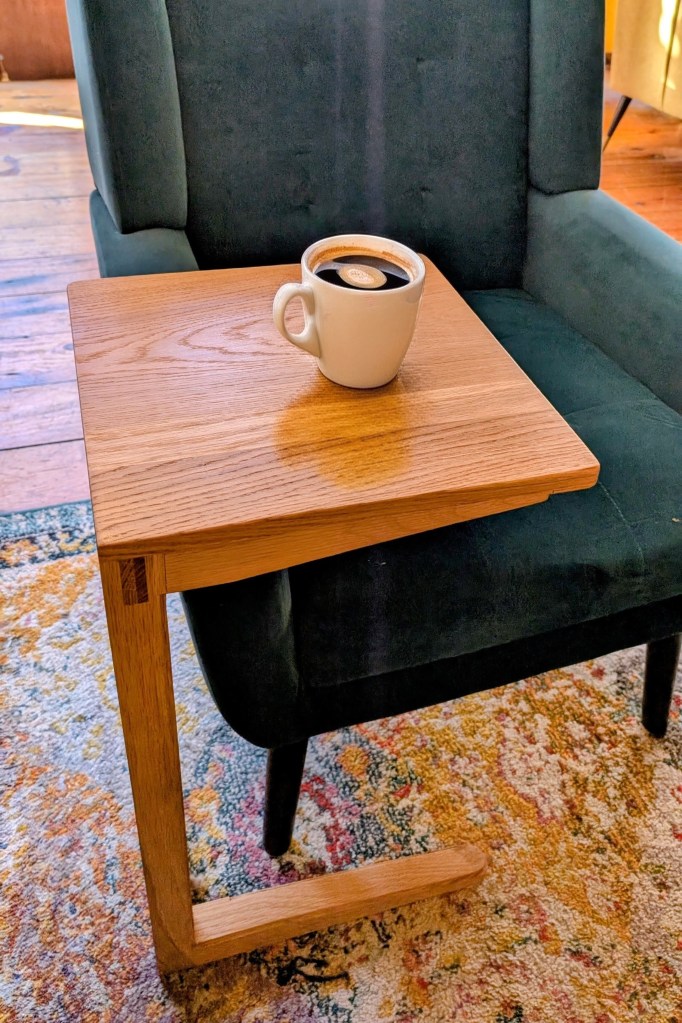 Cantilevered side table with coffee cup